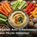 Snack vegetali anti-infiammatori: hummus con verdure, noci, frutta fresca e olive in ciotole colorate