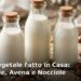 Bottiglie di vetro con latte vegetale fatto in casa di mandorle, avena e nocciole accanto agli ingredienti