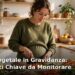 Donna incinta che prepara un pasto vegetale colorato con verdure, legumi e cereali in cucina